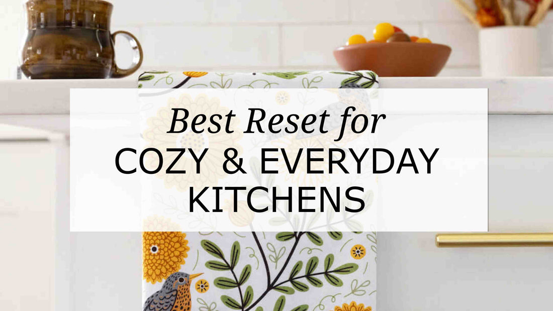 Cozy kitchen scene featuring a folk-art floral tea towel with birds and golden blooms, styled on a white cabinet with the text “Best Reset for Cozy & Everyday Kitchens.
