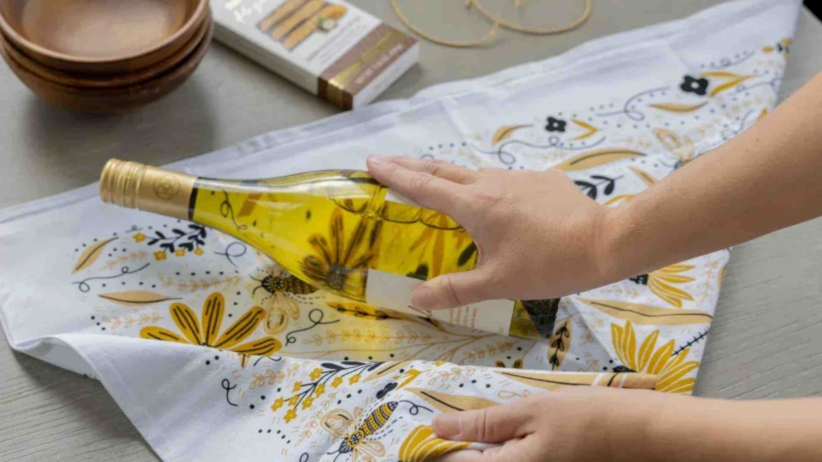 Illustrated tea towel by Gingiber — wrapped as a birthday gift with a botanical card on a bright tabletop