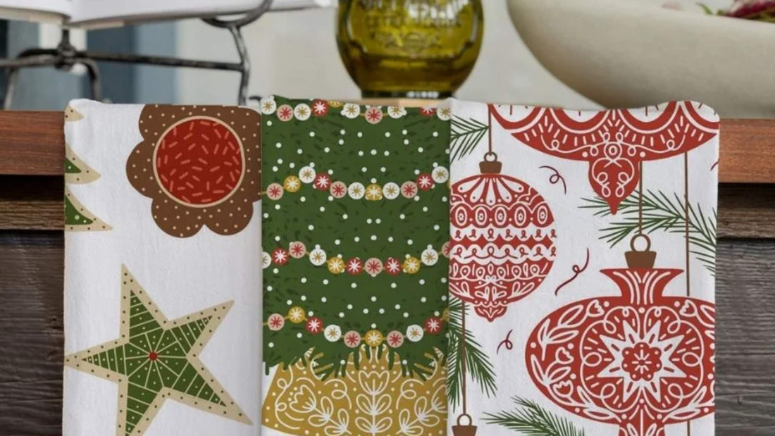 Christmas Traditions Tea Towel Bundle featuring festive cookies, a decorated Christmas tree, and red holiday ornaments displayed together in a kitchen.