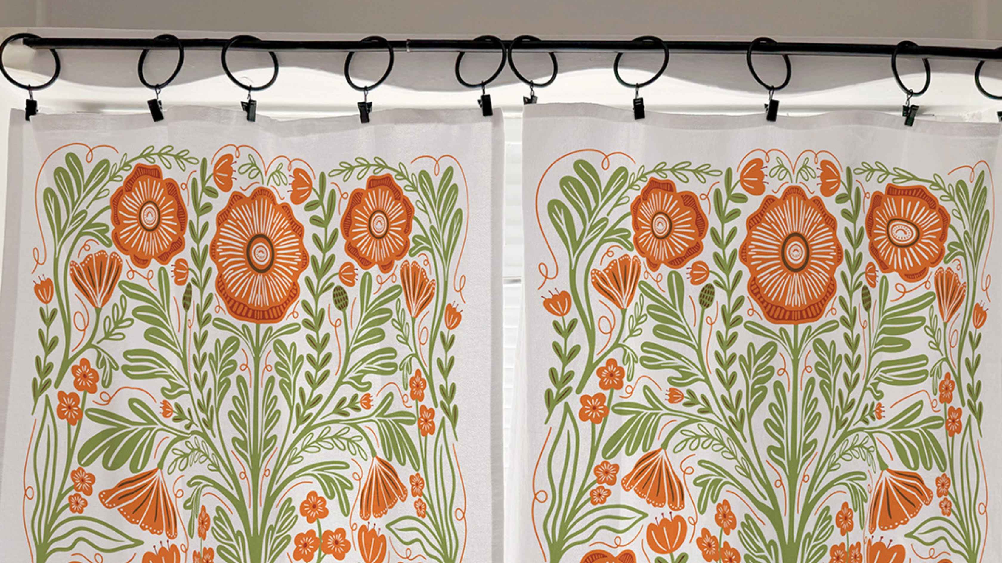 Poppy Cafe Curtains featuring bold orange poppies and green botanical details on a white background, hung with black clip rings for a charming no sew kitchen window treatment inspired by tea towels.