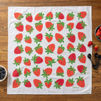 Tea towel with strawberry pattern on a wooden table