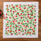 Tea towel with strawberry pattern on a wooden surface