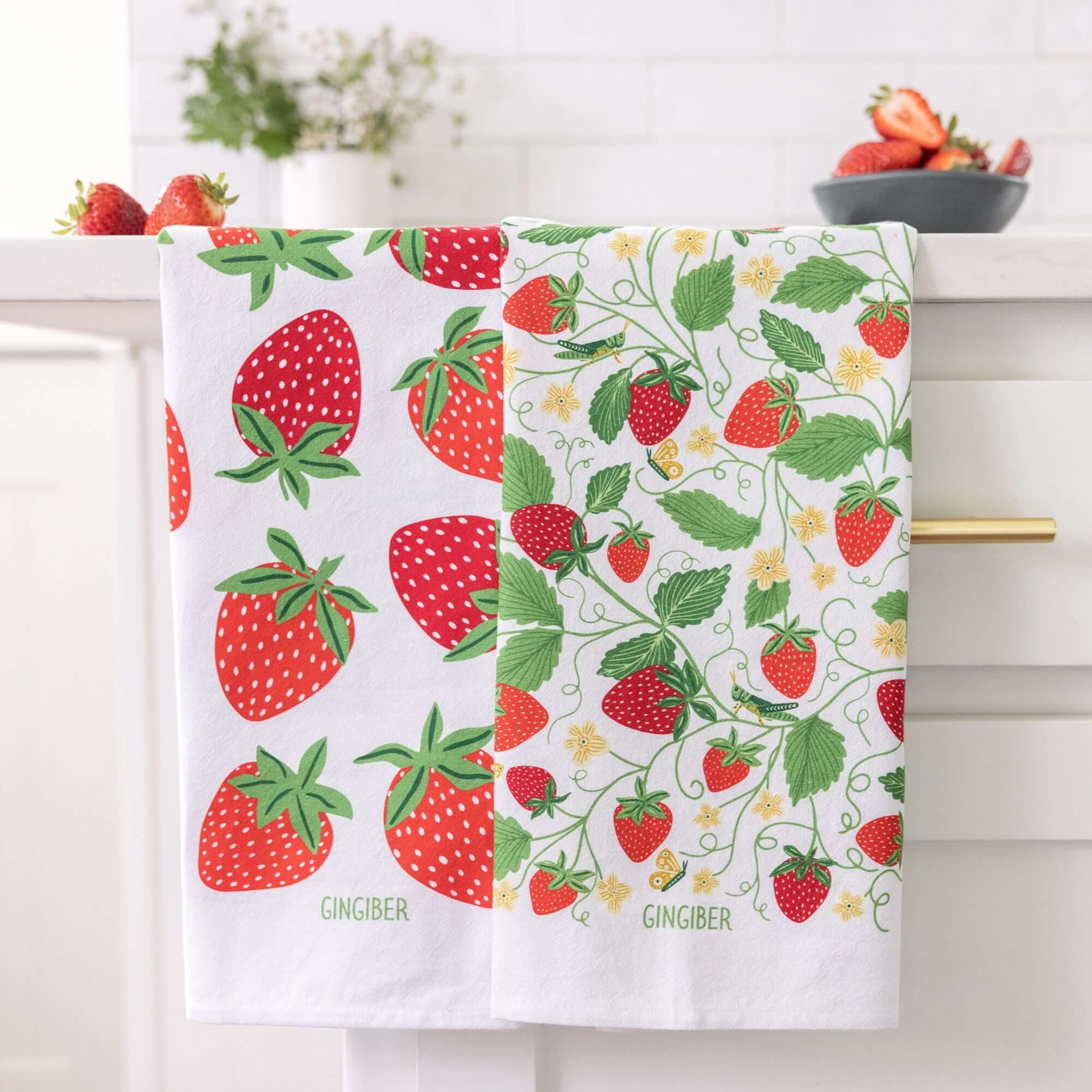 Strawberry-patterned fabric with a bowl of strawberries on a white background