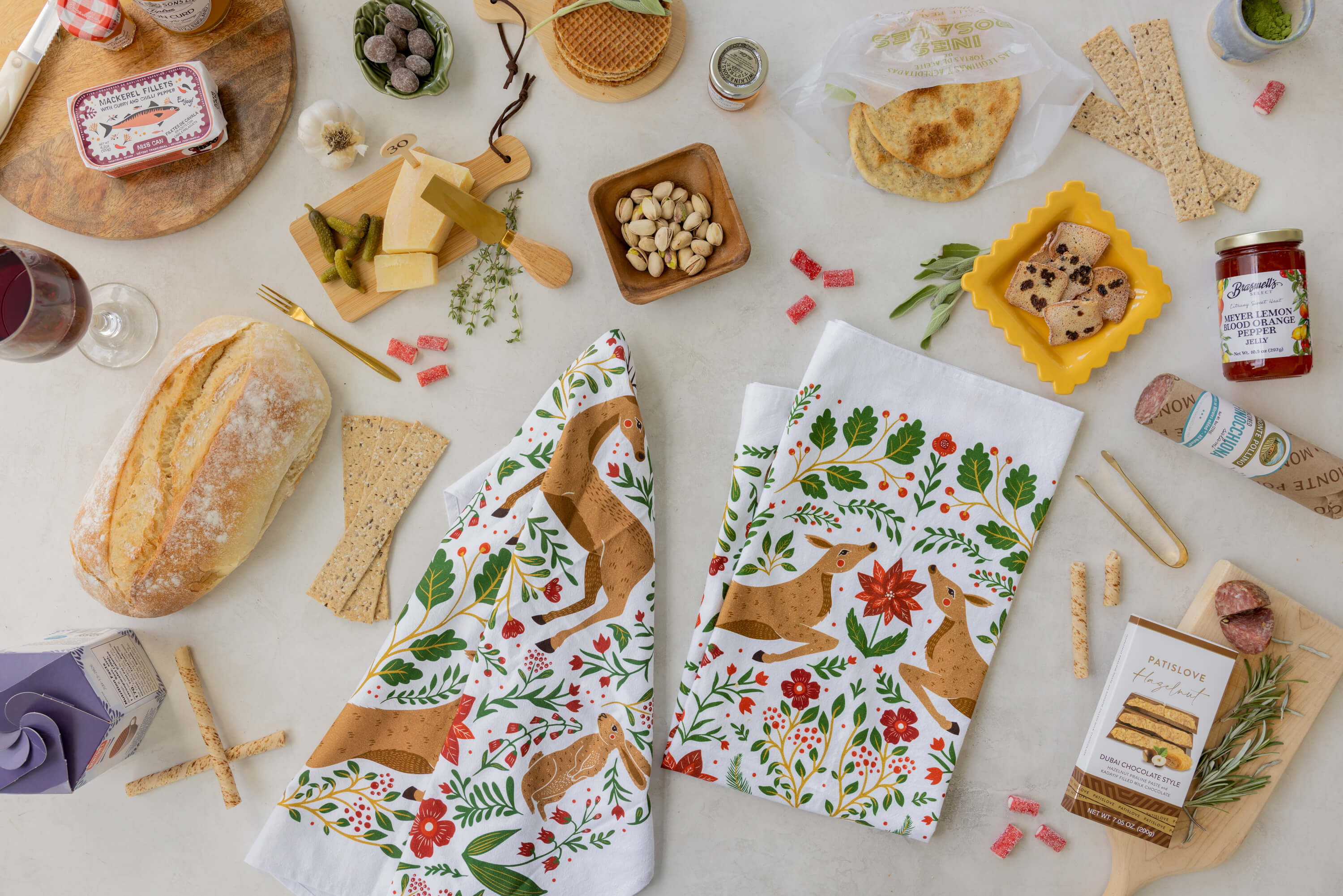 Two patterned towels with fox designs on a table with food items.
