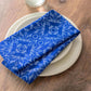 Blue floral-patterned napkin on a white plate on a wooden table