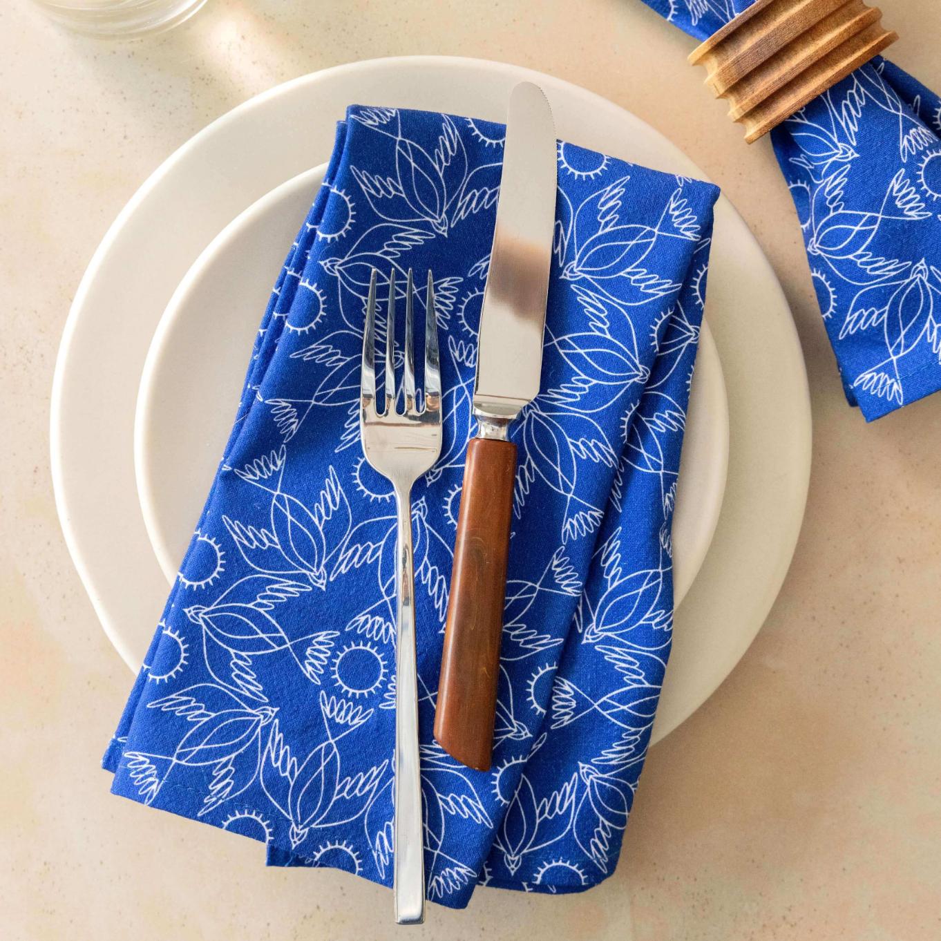 Blue patterned napkin with fork and knife on a white plate