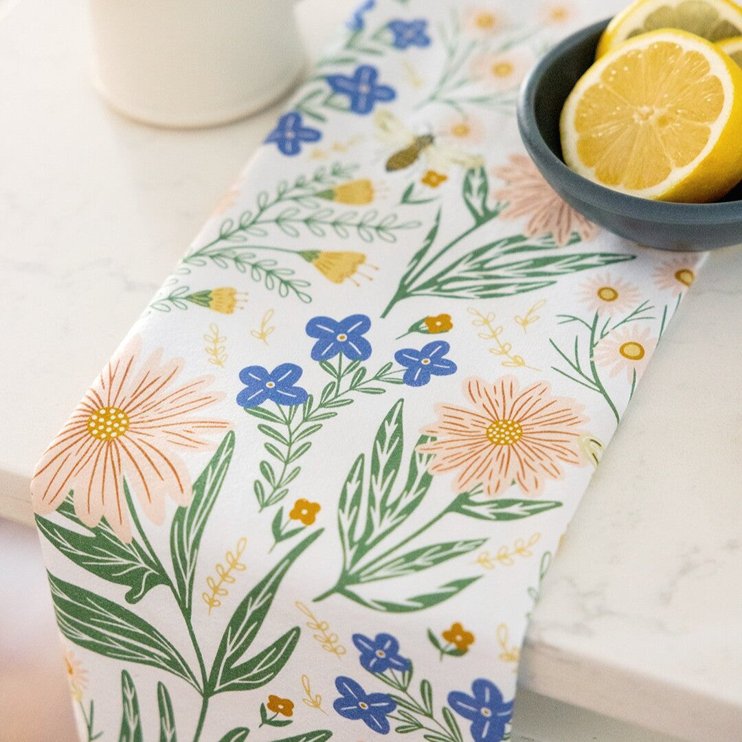 Floral-patterned tea towel with a bowl of lemons on a white surface