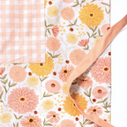 Zinnia Apron product image showcasing floral print and gingiber design with soft peach piping and tied waist, 100% cotton canvas