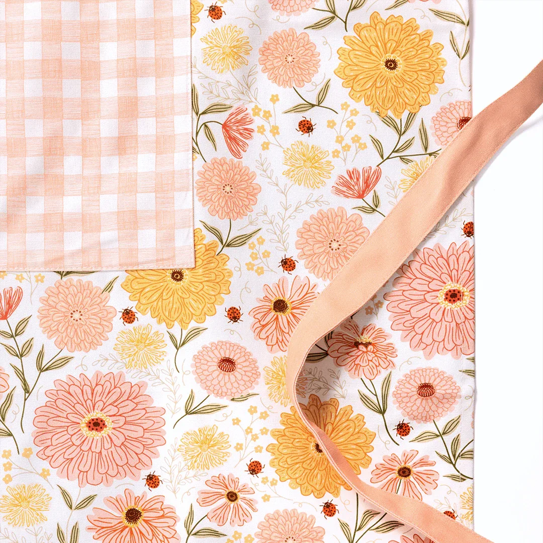 Zinnia Apron and Tea Towel Bundle showcasing floral design with adjustable neck strap and large pocket.