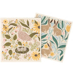 Two decorative towels with nature-themed designs featuring birds, bunnies, and flowers on a white background.