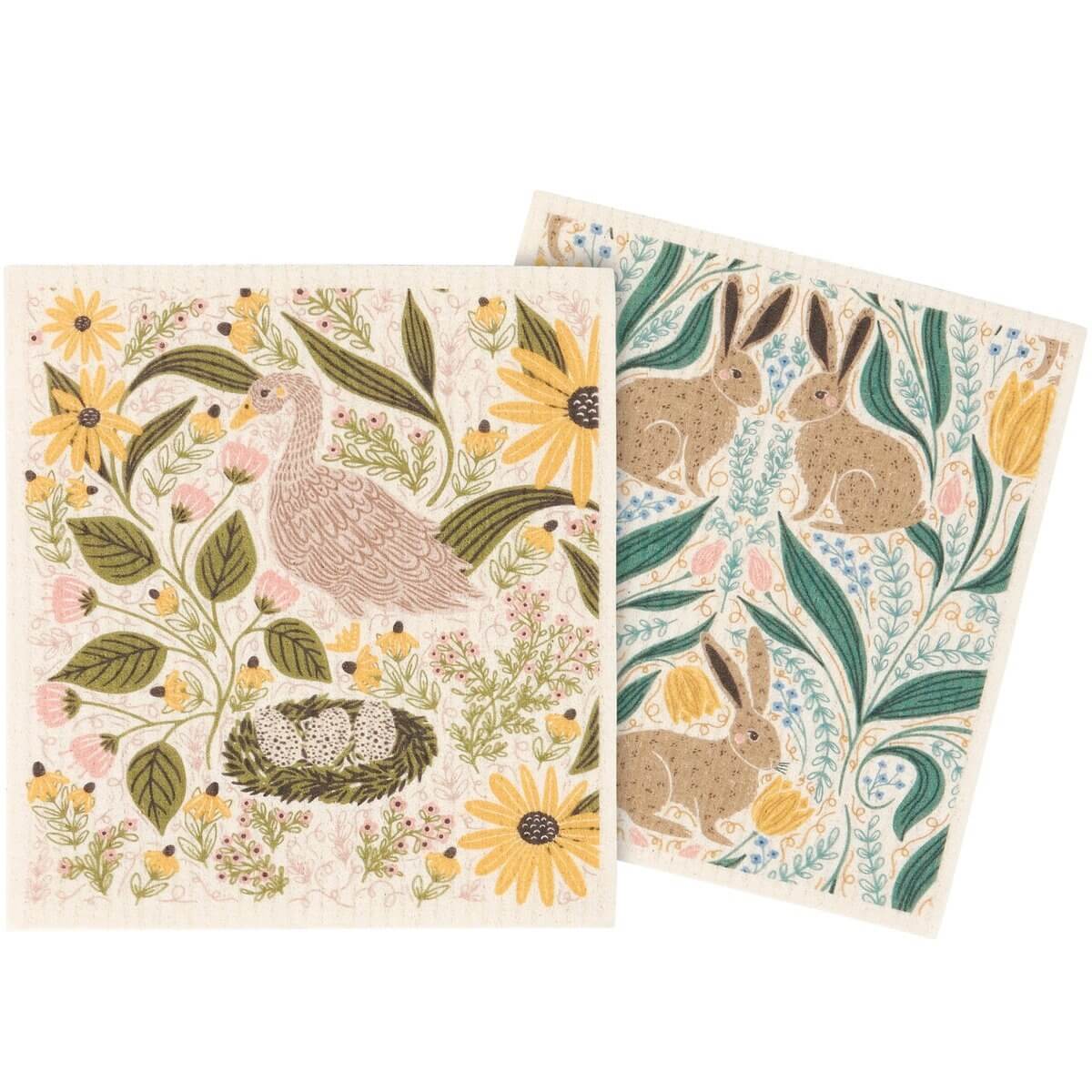 Two decorative towels with nature-themed designs featuring birds, bunnies, and flowers on a white background.