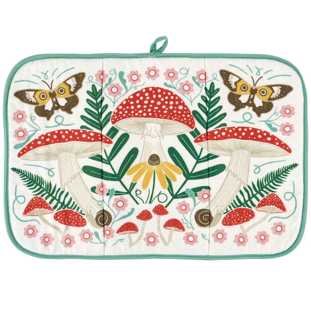 A square quilted potholder with a colorful woodland design featuring red and white mushrooms, green ferns, pink flowers, yellow flowers, and butterflies on an off-white background, finished with a mint green border and top loop.