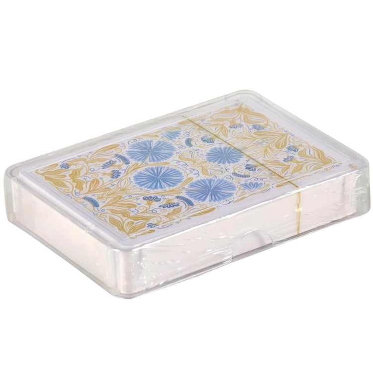 Playing cards with floral design in a transparent box on a white background
