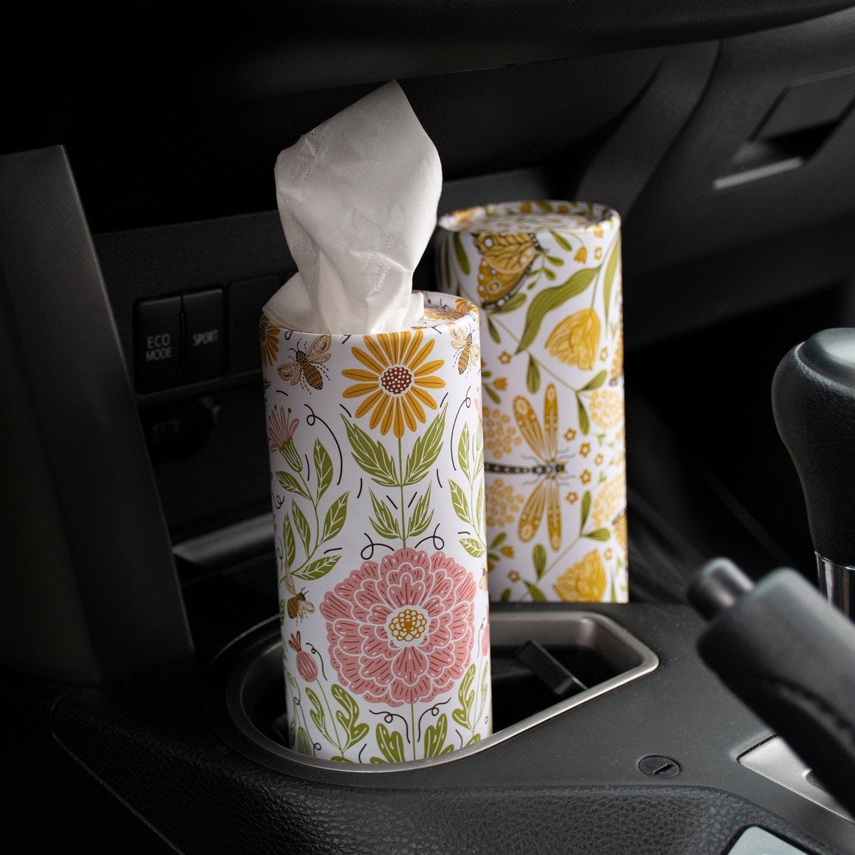 Floral-patterned tissue boxes in a car cup holder