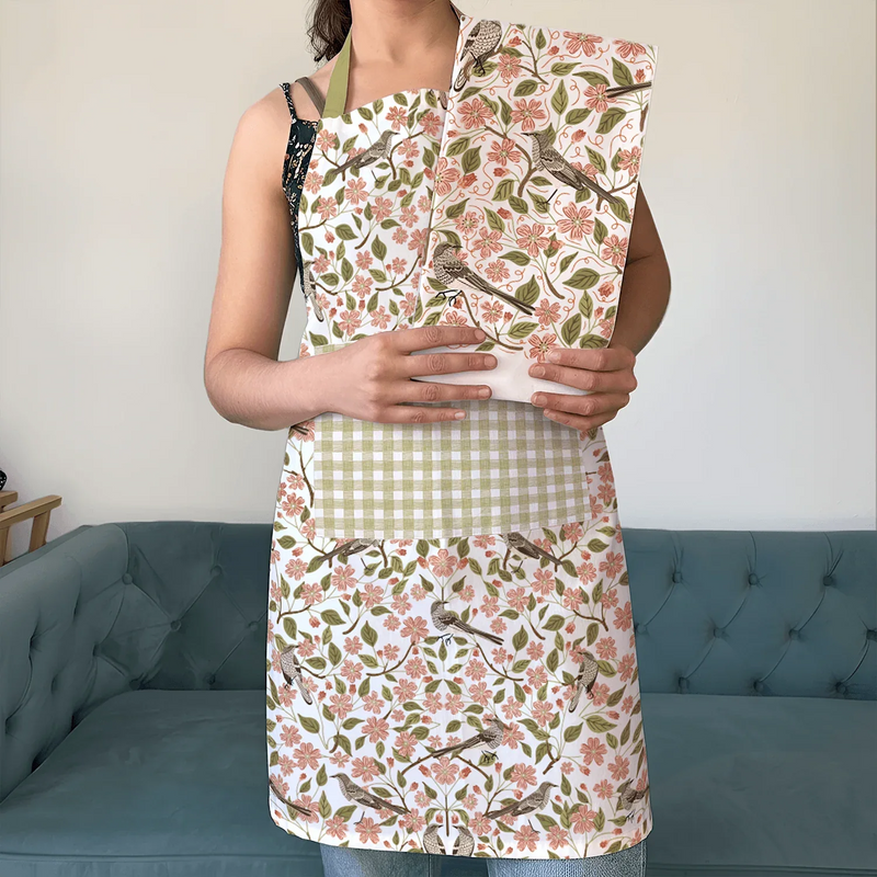 Apple Blossom Apron and Tea Towel Bundle - person wearing floral apron and matching tea towel bundle with checkered pocket, indoor setting