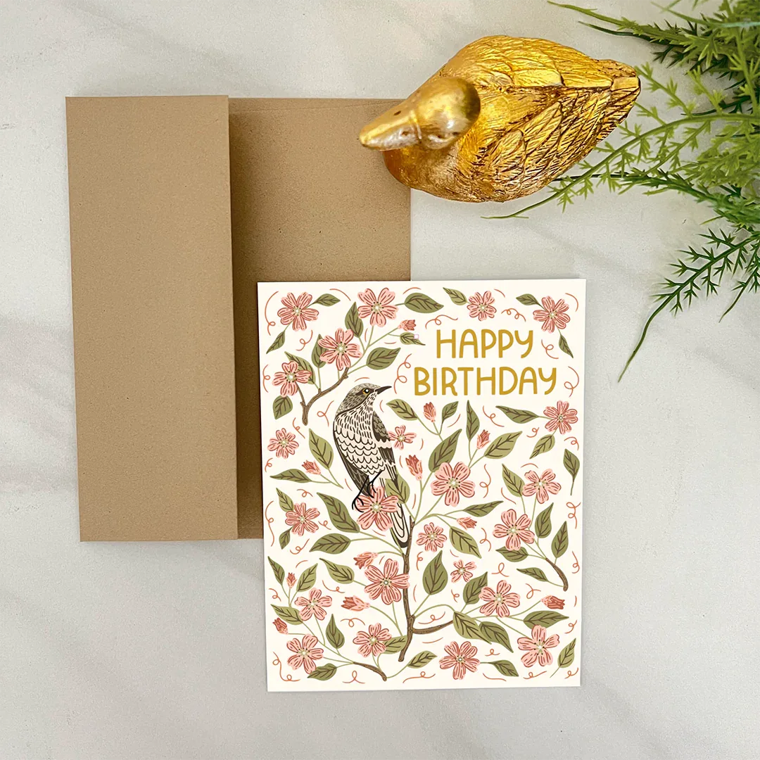 Apple Blossom Birthday Card displayed alongside a kraft envelope with floral illustration and bird design for a cheerful birthday greeting.