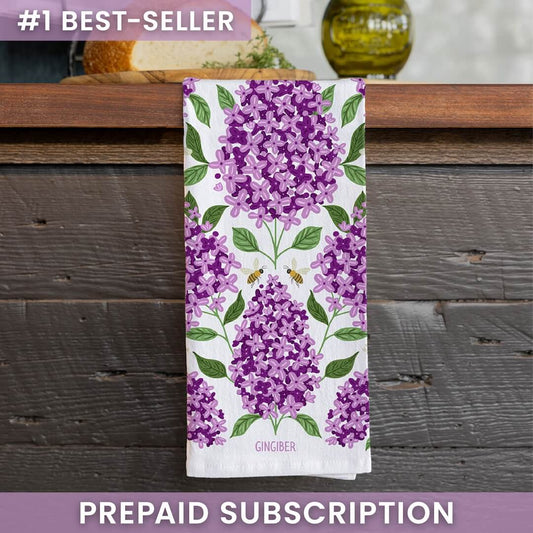 Towel with purple floral design on a wooden surface, featuring the brand 'Gingiber'.