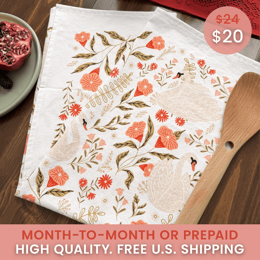 Floral-patterned towel with price tags and promotional text on a wooden surface