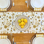 bundle of tabletop products - white table runner with bee and floral elements, gold gingham cloth napkins