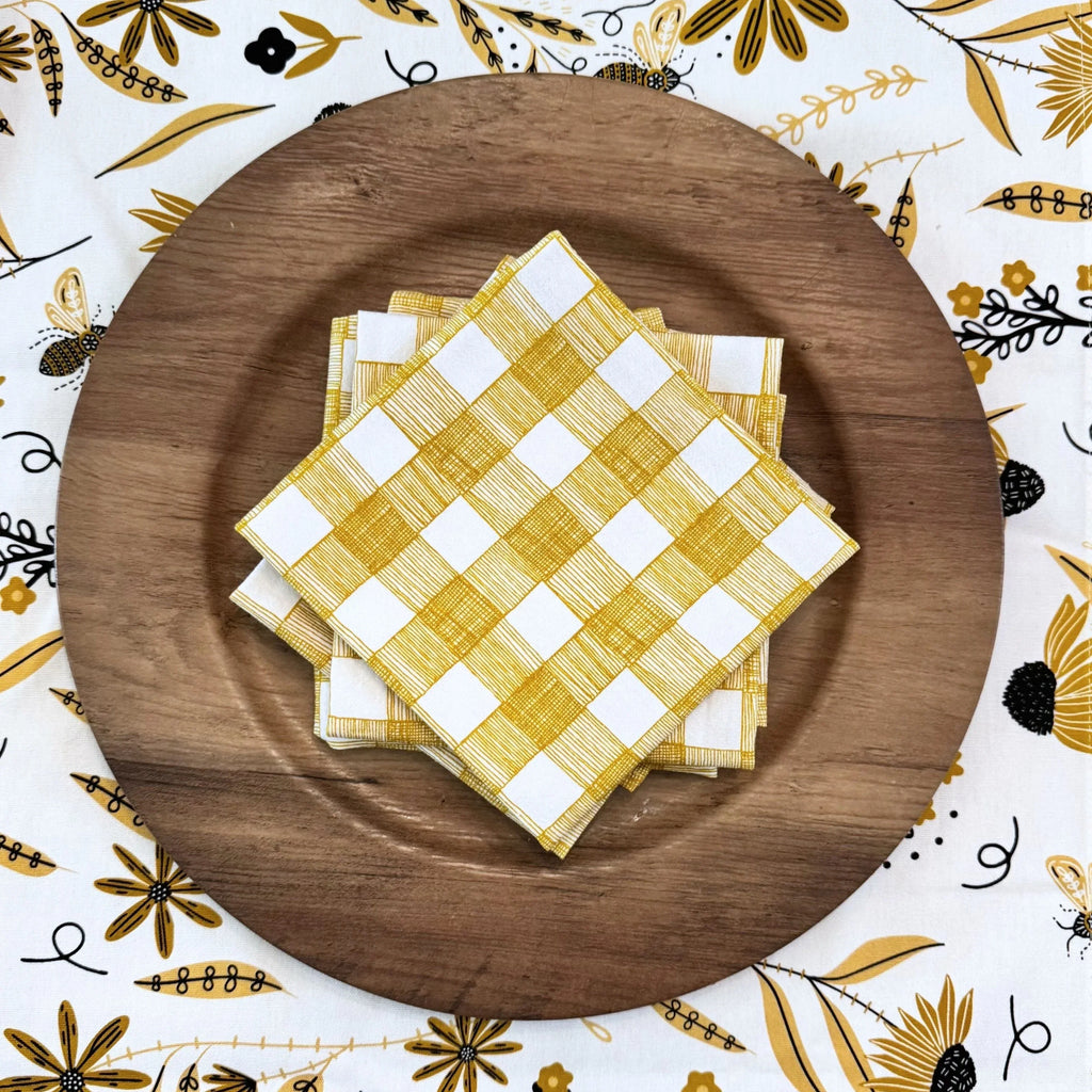 bundle of tabletop products - white table runner with bee and floral elements, gold gingham cloth napkins