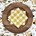 bundle of tabletop products - white table runner with bee and floral elements, gold gingham cloth napkins