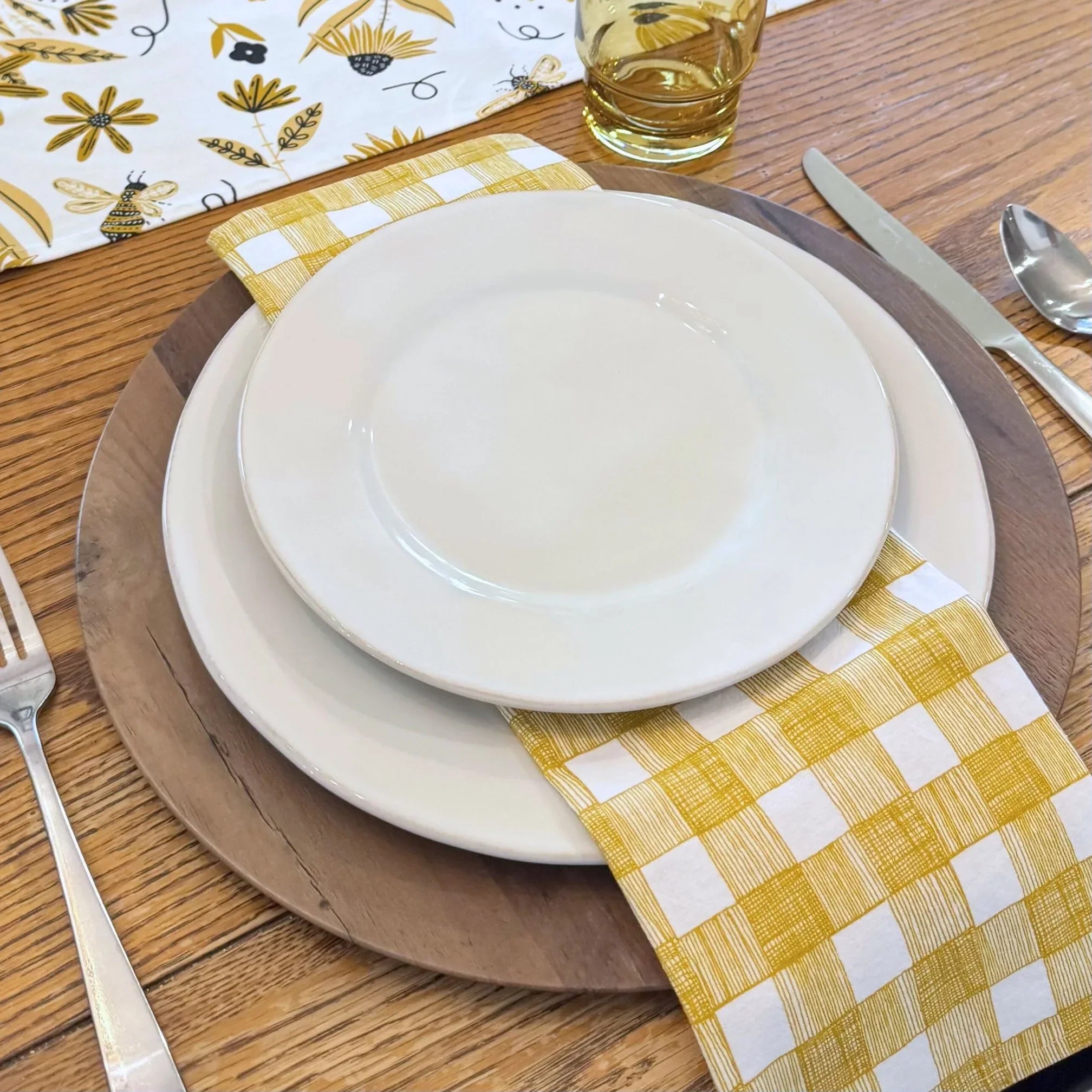 bundle of tabletop products - white table runner with bee and floral elements, gold gingham cloth napkins