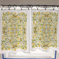 Pair of patterned curtains with yellow and green design on a rod.