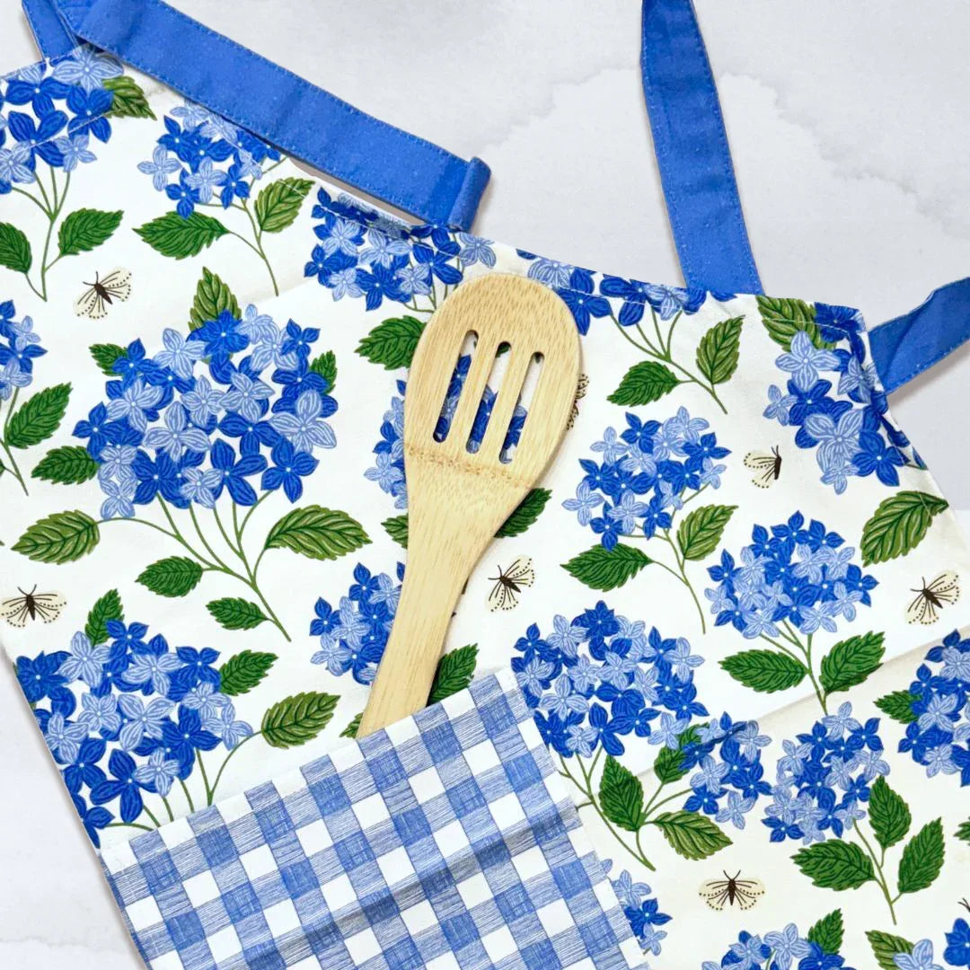 Hydrangea Apron—bake in style with gingiber apron featuring blue hydrangea print, adjustable neck strap, large pocket, 100% cotton canvas