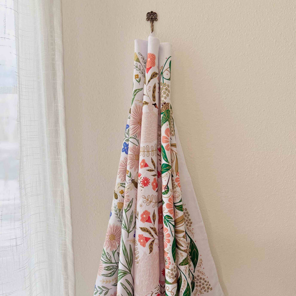 Floral-patterned fabric hanging on a hook against a neutral wall.