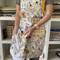 Bee Garden Apron & Tea Towel—bake in style with gingiber apron featuring bee and floral print and matching tea towel, adjustable neck strap, large pocket, 100% cotton canvas