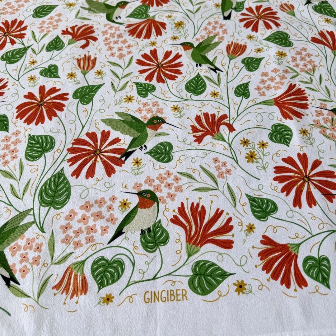 Patterned fabric with hummingbirds and flowers, featuring the brand 'Gingiber'.