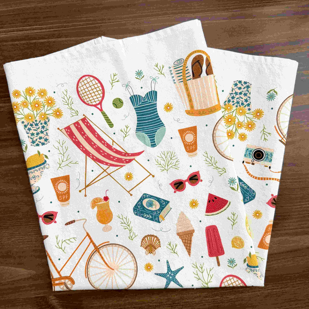 Folded towel with summer-themed designs on a wooden surface