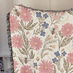 Floral patterned blanket with pink flowers and bees on a white background