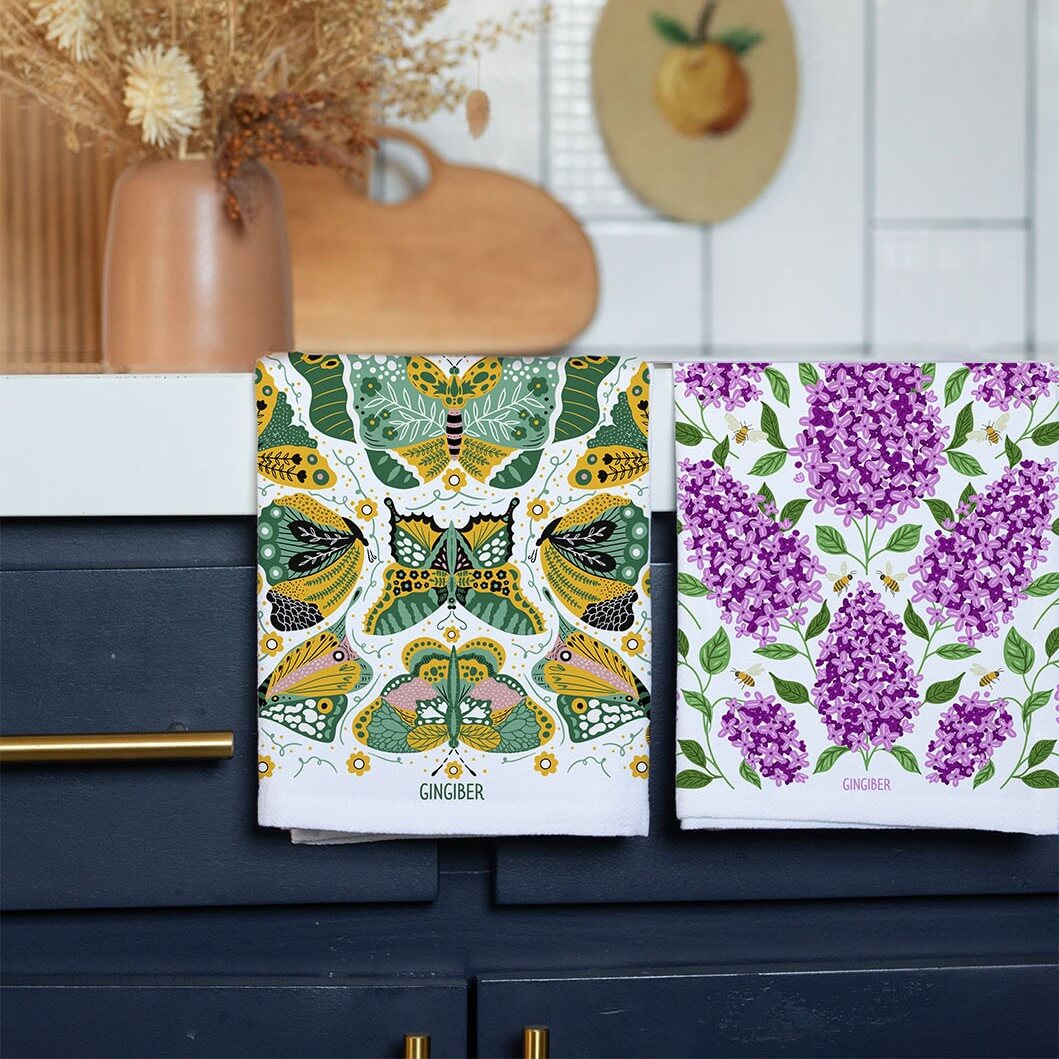 Two patterned notebooks on a kitchen counter with a decorative background.