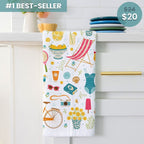 Colorful towel with summer-themed designs hanging on a cabinet handle.