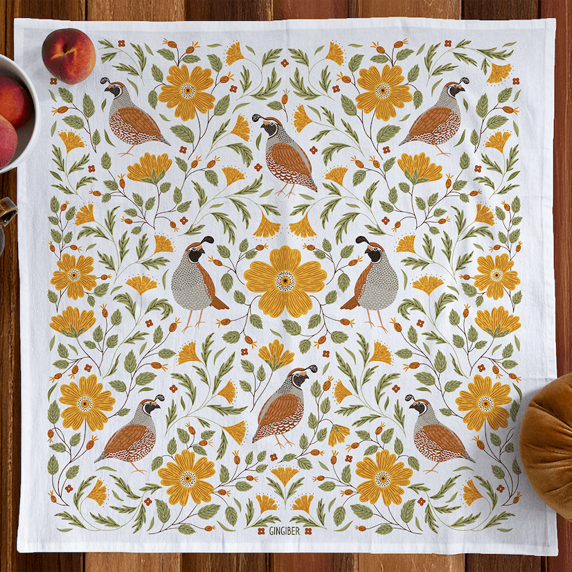 Decorative towel with floral and bird pattern on a wooden surface