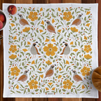 Decorative towel with floral and bird pattern on a wooden surface