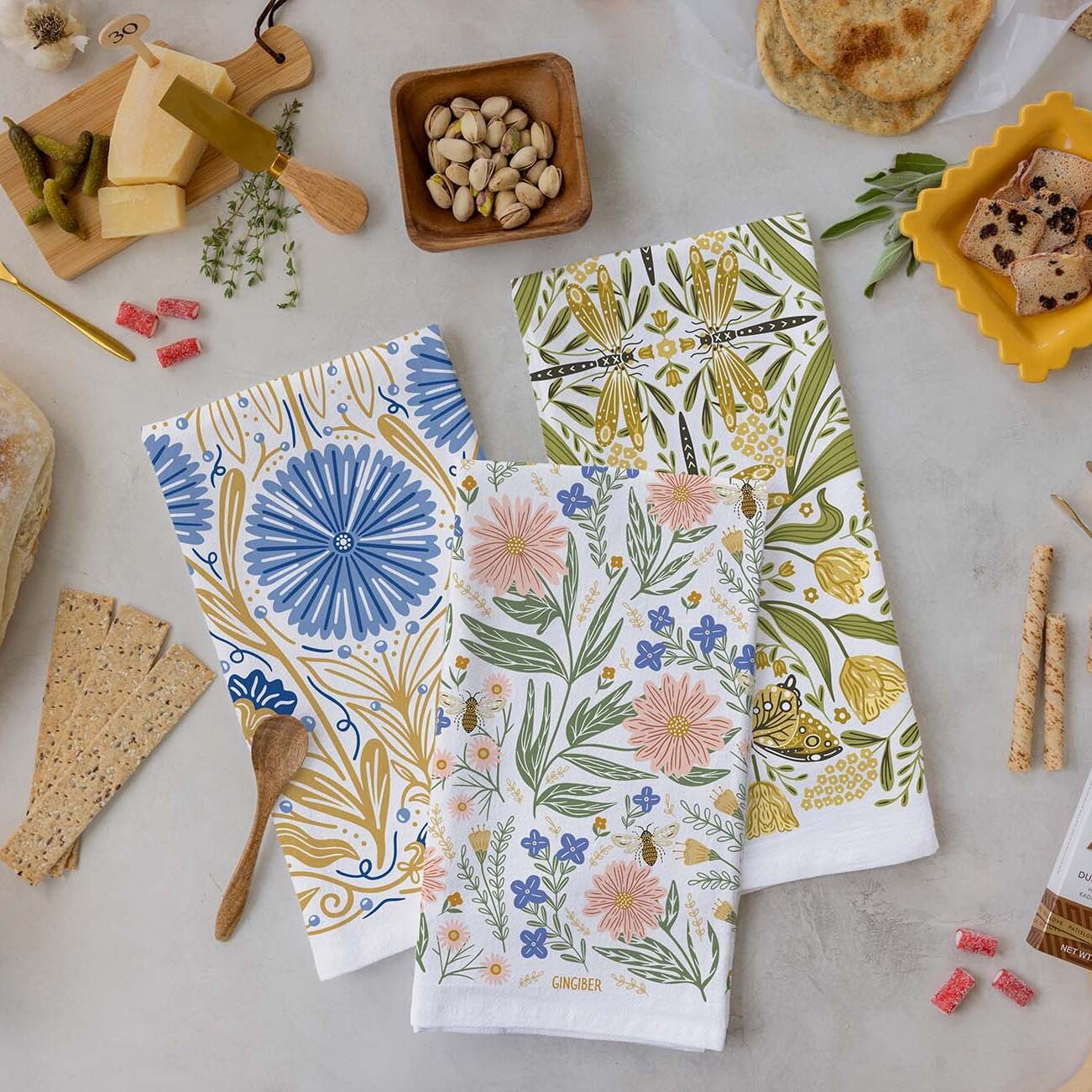 Three patterned towels on a table with food items