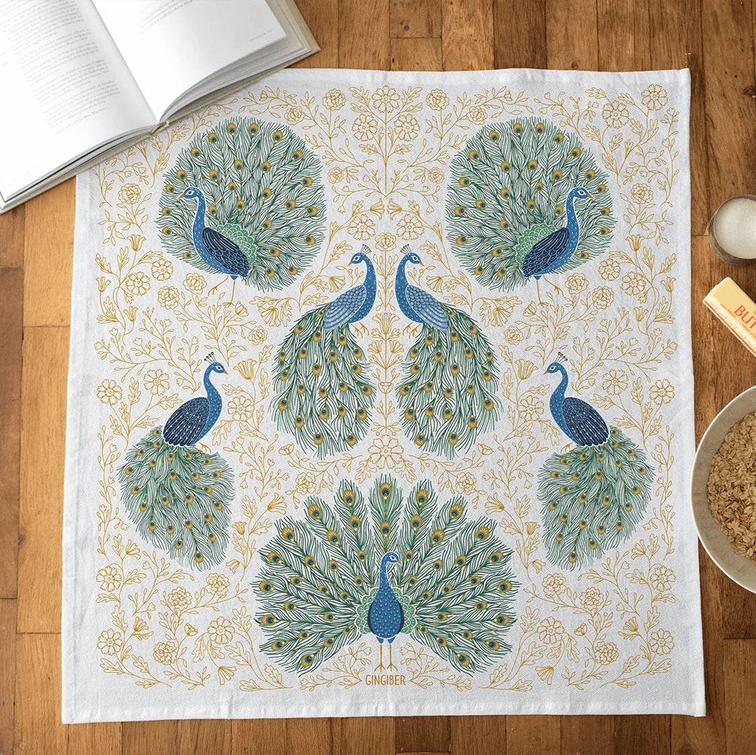 Decorative towel with peacock pattern on a wooden surface