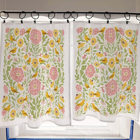 Floral and bird patterned curtains on a rod with a tiled floor background
