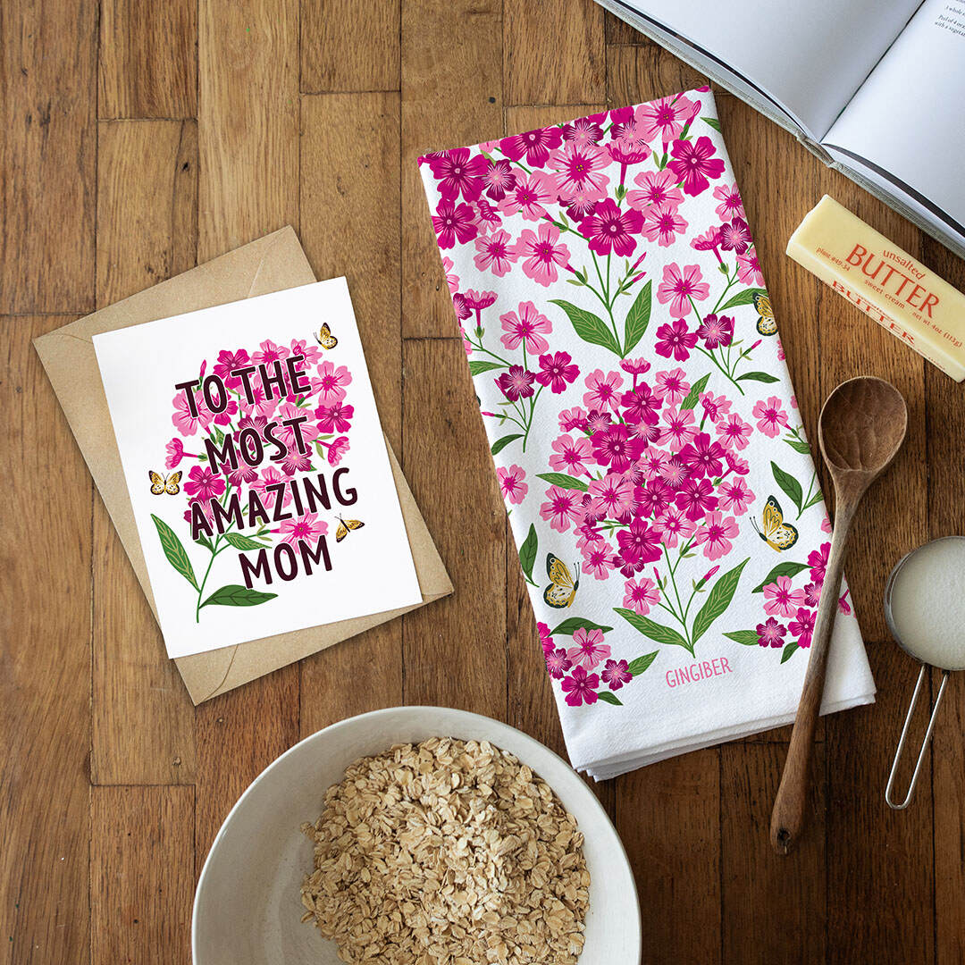 Floral towel, card, and bowl on a wooden surface