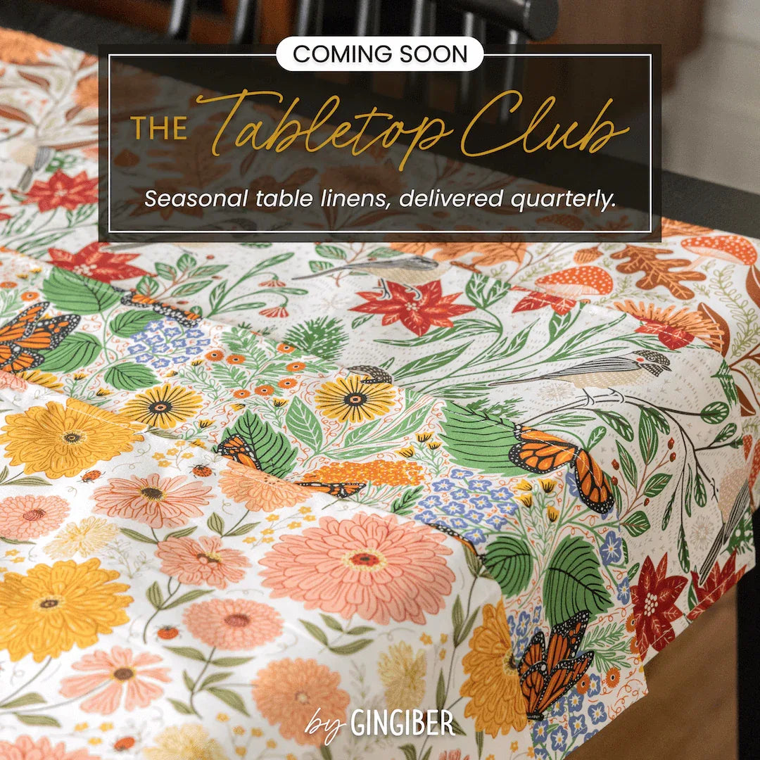 The Tabletop Club seasonal table linens featuring colorful floral designs on a beautifully set table.