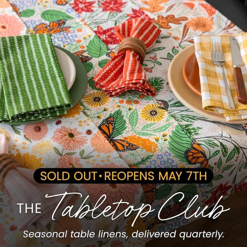 Colorful table setting with floral tablecloth and text about The Tabletop Club.