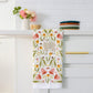 Decorative kitchen towel with floral and llama design hanging on a cabinet handle.