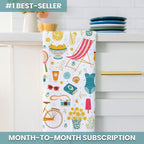 Colorful towel with summer-themed design hanging on a kitchen rack.