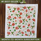Decorative tablecloth with floral and bird pattern on a wooden surface, labeled as a best-seller with a month-to-month subscription offer.