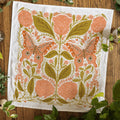 Decorative towel with floral and butterfly pattern on a wooden surface