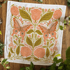 Decorative towel with floral and butterfly pattern on a wooden surface