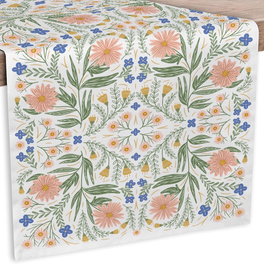 Floral patterned tablecloth with pink, blue, and green flowers on a white background