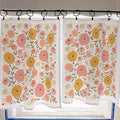 Floral patterned curtains hanging on a rod with a window in the background.